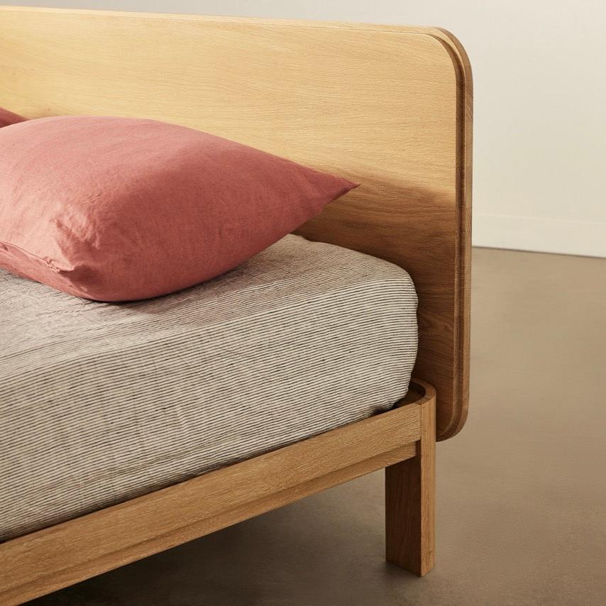 Coral timber bed frame in solid oak with curved legs and storage-ready design