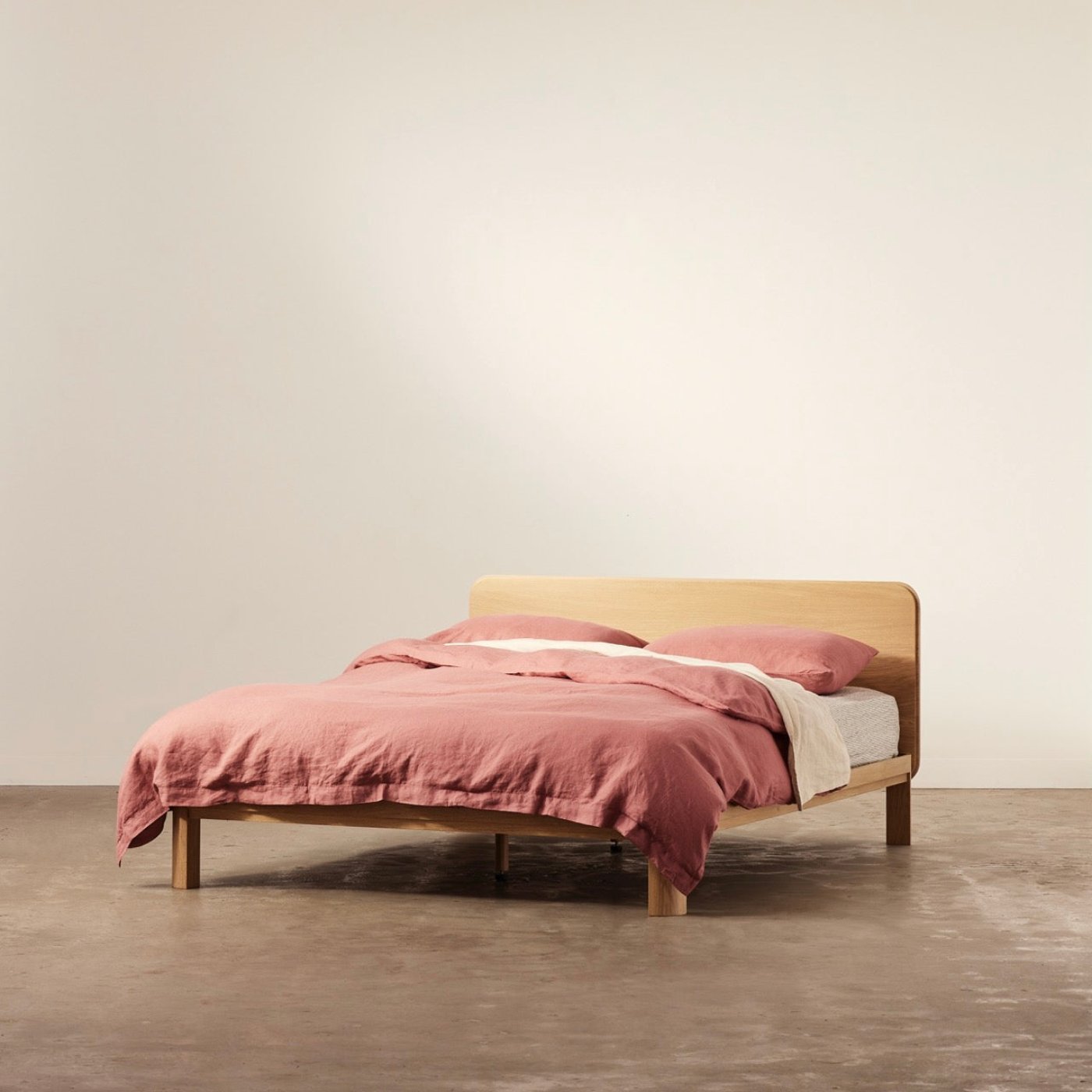 Coral timber bed frame in solid oak with curved legs and storage-ready design