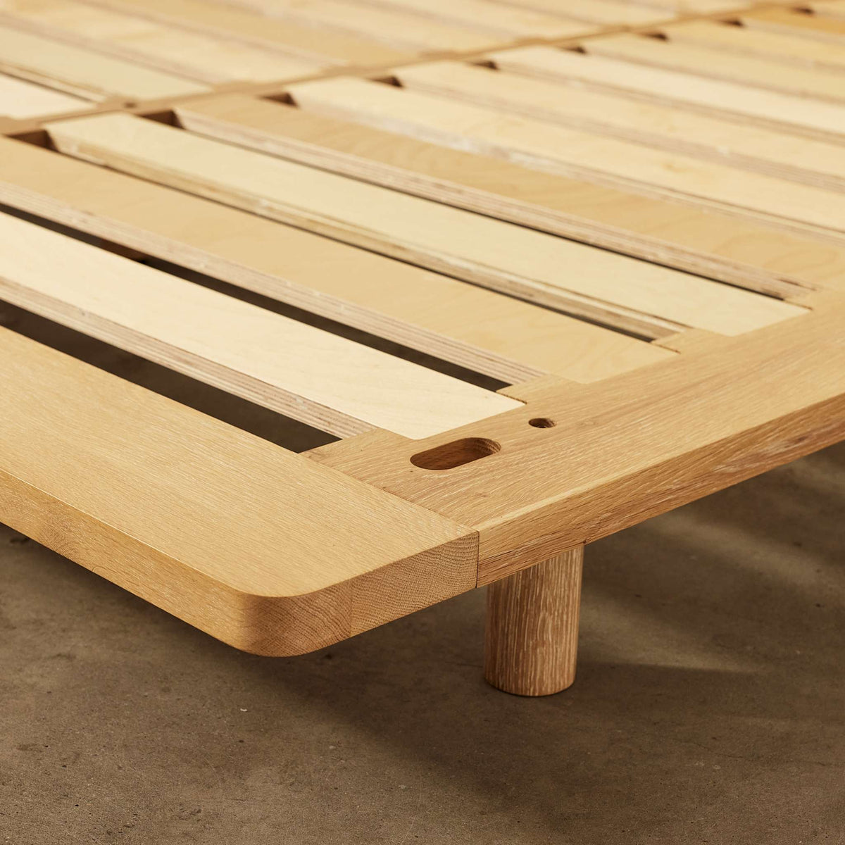 Corner detail of Lagos timber bed frame showing solid oak construction and durable slatted base – Totem Road