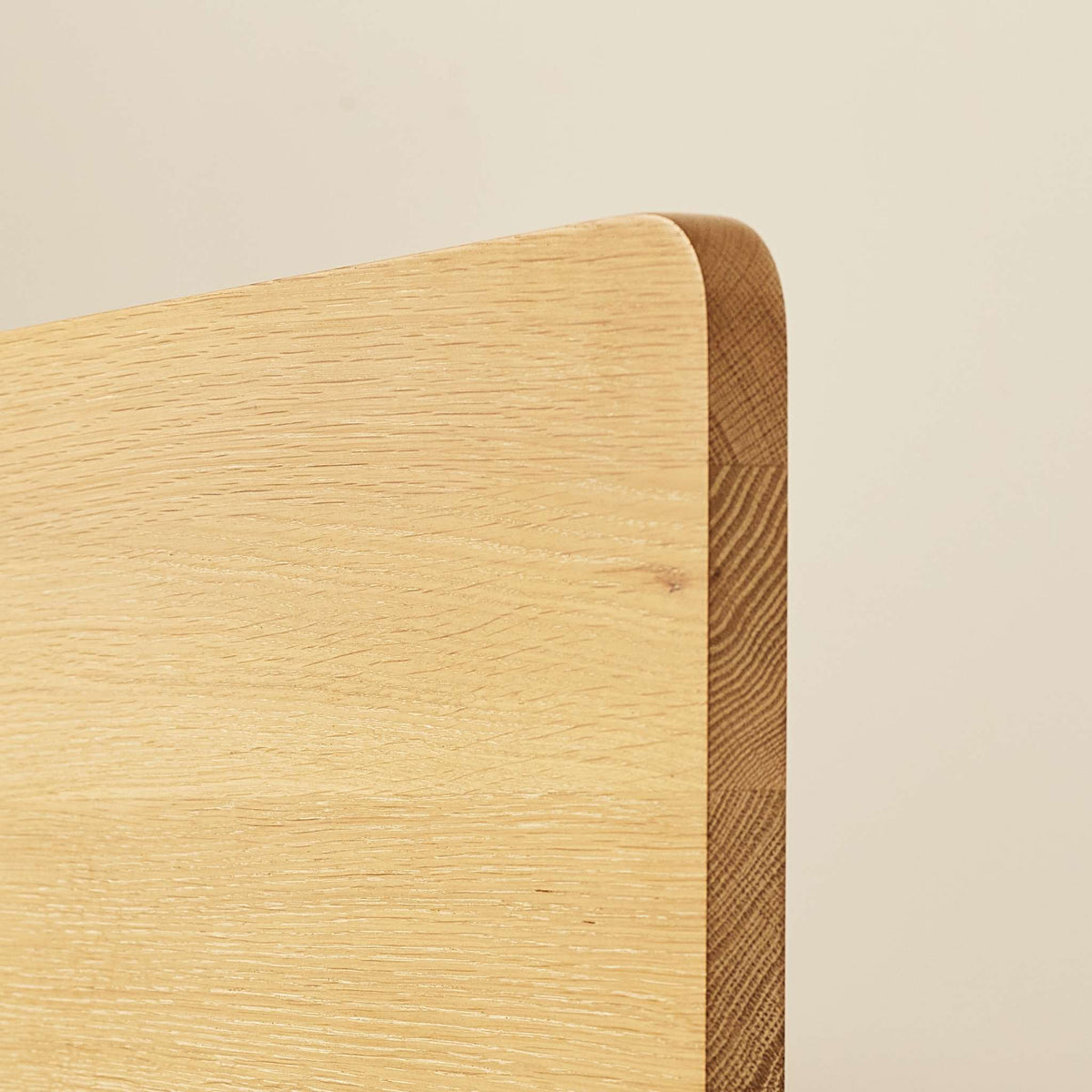 Detail of Lagos bed frame headboard showing rounded edges and natural grain of solid oak - Totem Road